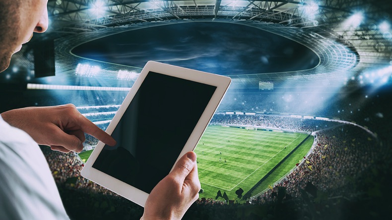 Man with a tablet at a football stadium