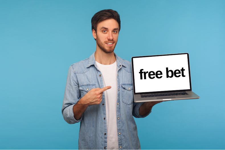 Man holding laptop that says 'Free Bet'